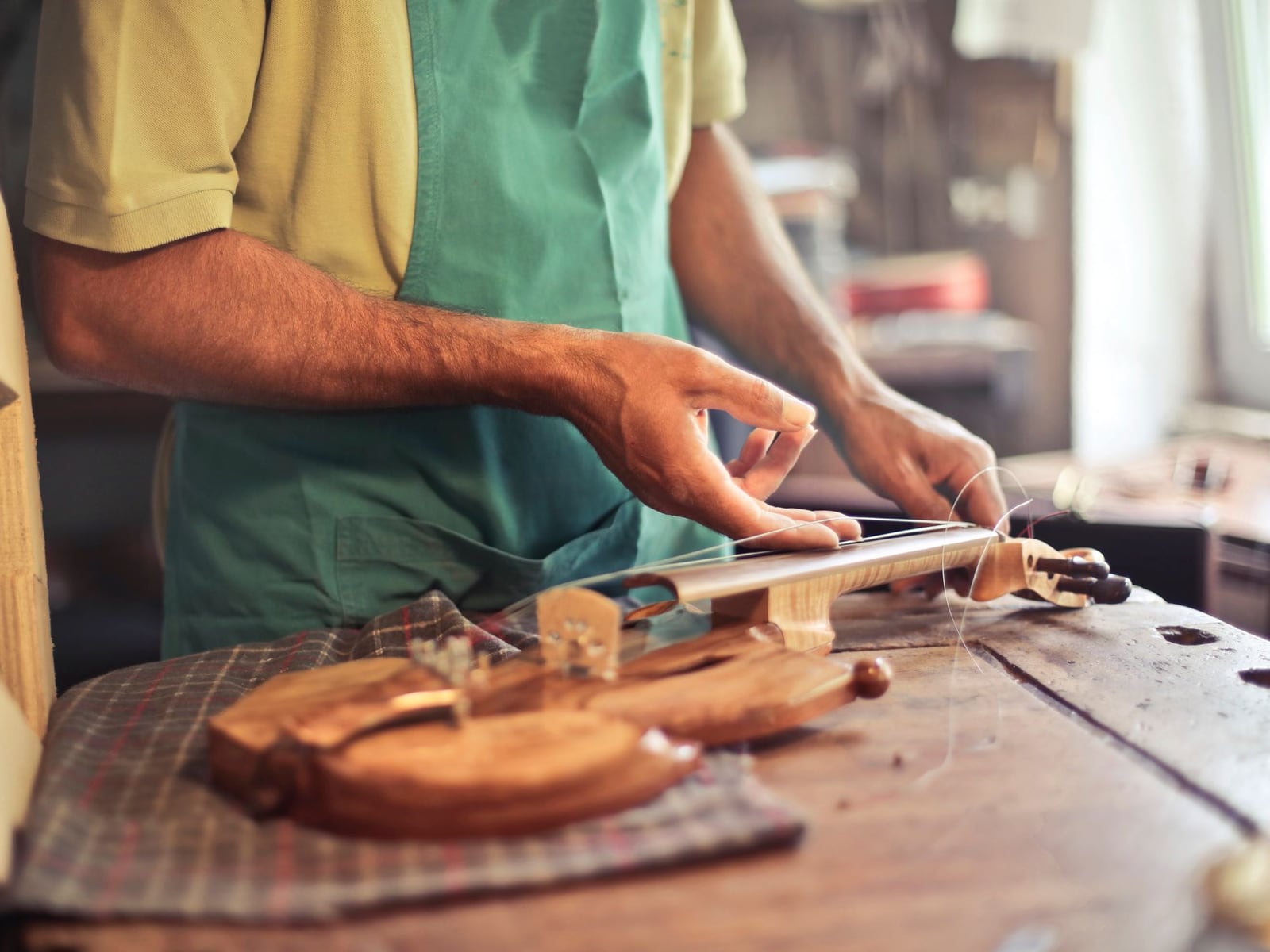 Professionelle Inspektion einer Violine auf einem weichen Tuch in der Instrumentenbauwerkstatt