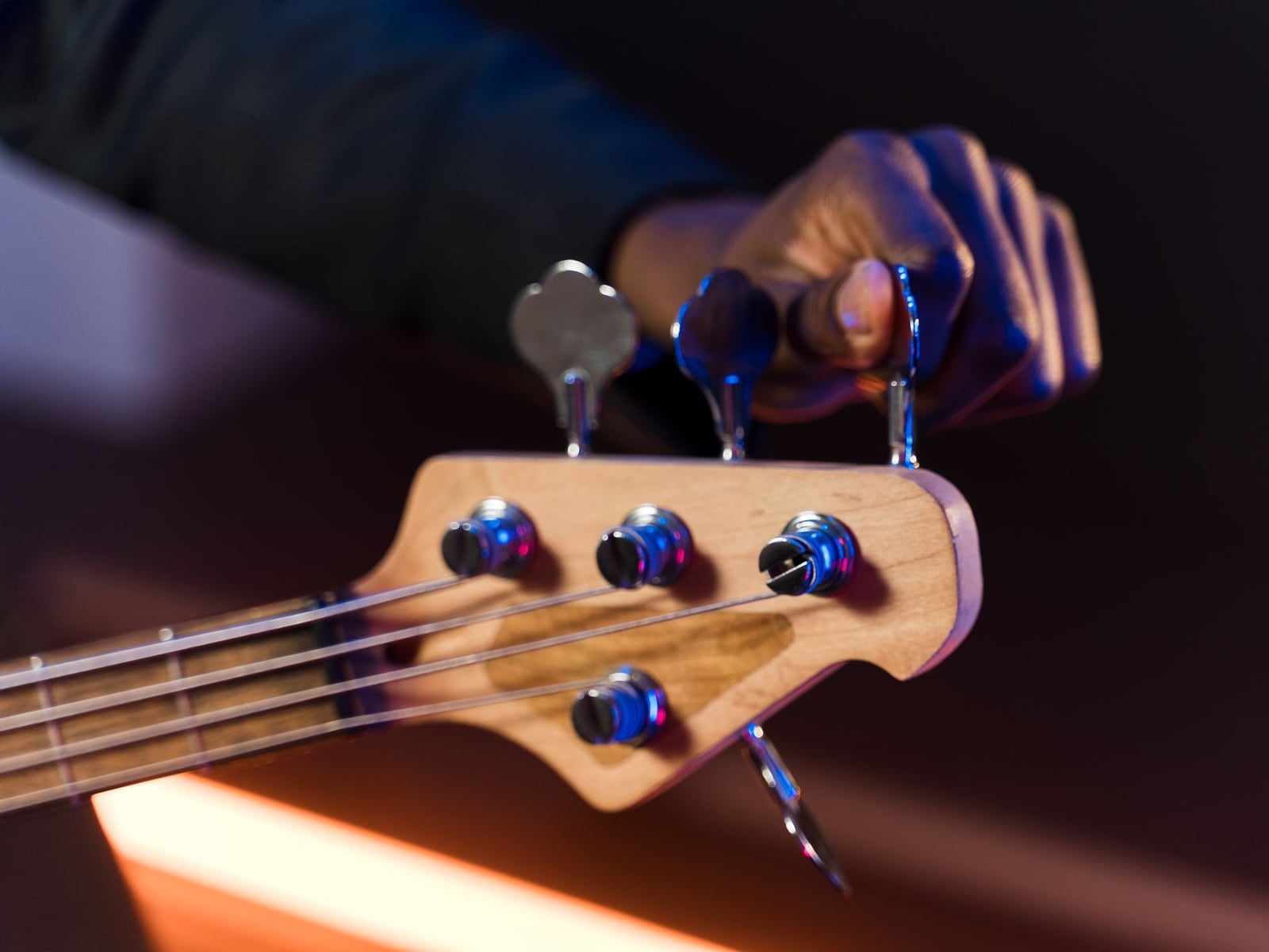 Nahaufnahme einer präzisen Saitenhöhenregulierung an einer akustischen Gitarre in der Werkstatt