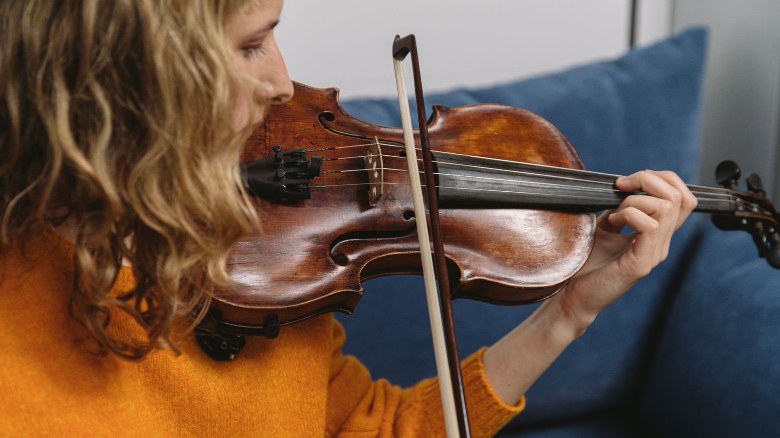 Neue Violinsaiten und ein Bogen, der neu bespannt wird, auf einer Holzoberfläche